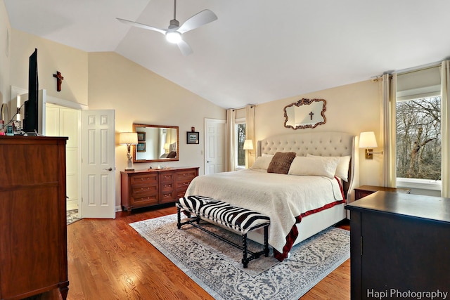 bedroom with a ceiling fan, vaulted ceiling, and wood finished floors