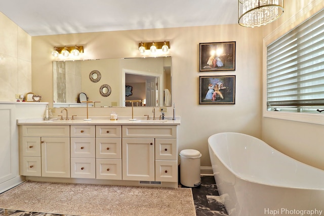 bathroom with a soaking tub, a sink, and double vanity