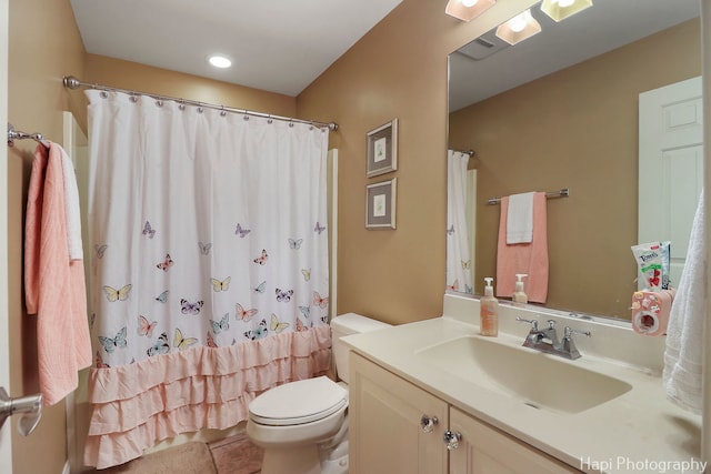 bathroom featuring tile patterned flooring, a shower with shower curtain, vanity, and toilet