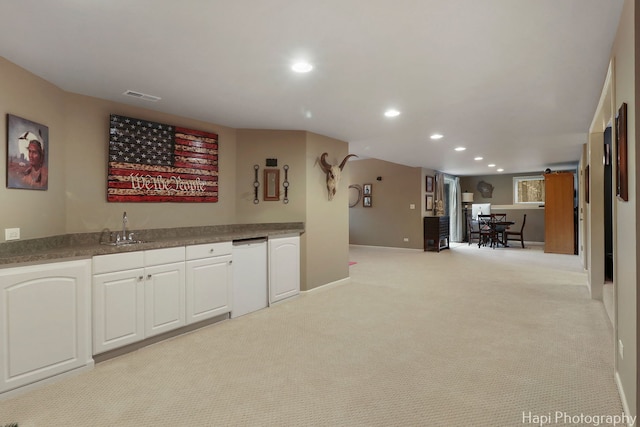 kitchen featuring visible vents, dishwasher, light colored carpet, a sink, and recessed lighting