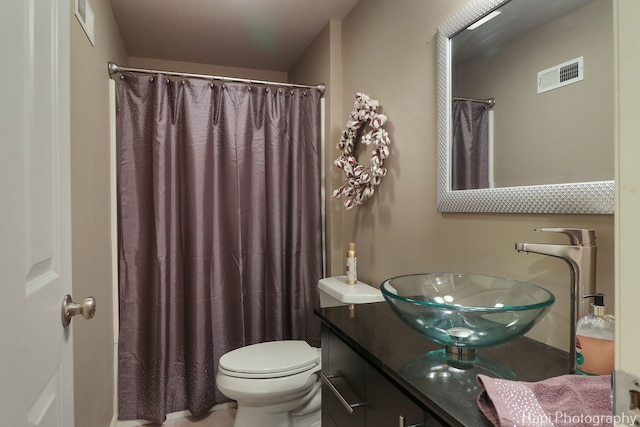 bathroom with curtained shower, visible vents, vanity, and toilet