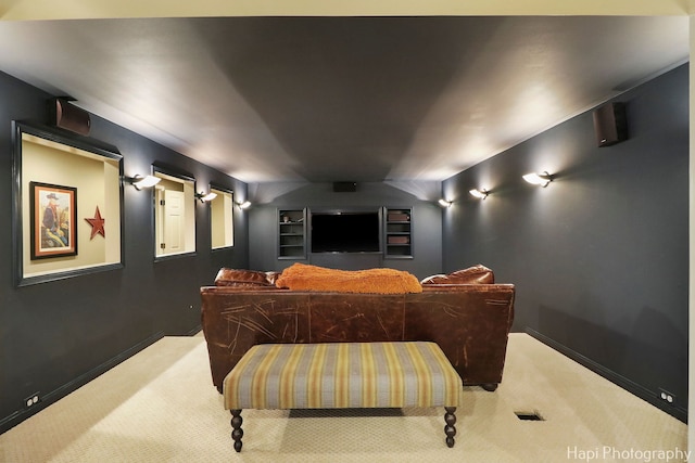 home theater room featuring light colored carpet and baseboards