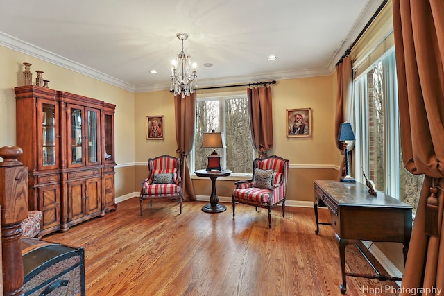 sitting room with baseboards, ornamental molding, wood finished floors, and a notable chandelier