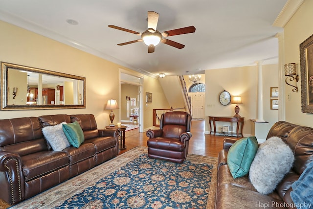 living area with crown molding, wood finished floors, decorative columns, and a ceiling fan