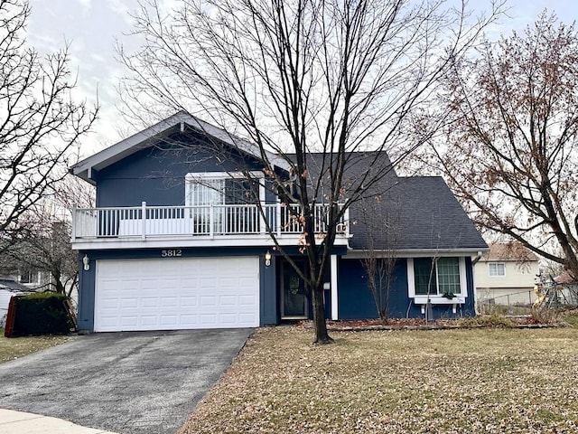 view of front facade with driveway, an attached garage, and roof with shingles