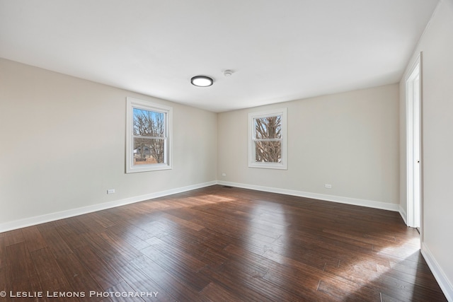 empty room featuring dark wood-style floors and baseboards