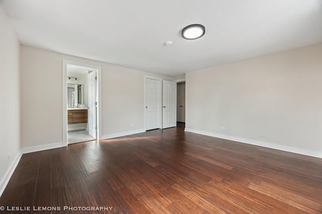 unfurnished bedroom with dark wood-type flooring and baseboards