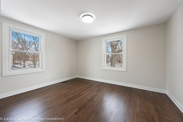 empty room featuring visible vents, plenty of natural light, and baseboards