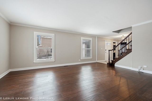 spare room featuring crown molding, visible vents, wood finished floors, baseboards, and stairs