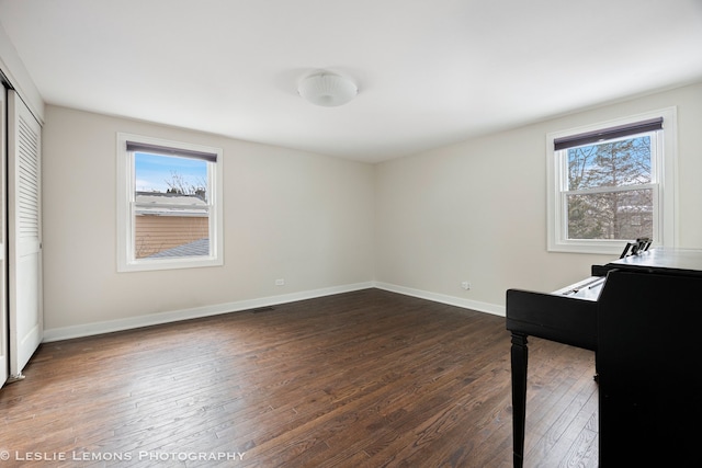 bedroom featuring dark wood-type flooring, a closet, and baseboards