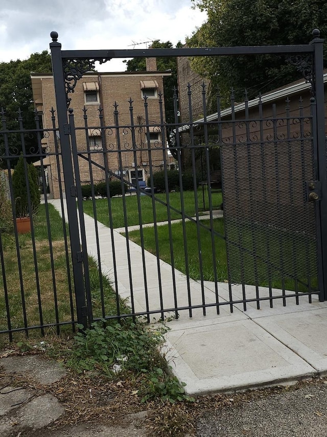 view of gate featuring a lawn and fence