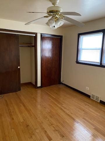 unfurnished bedroom featuring light wood-type flooring, baseboards, visible vents, and a ceiling fan