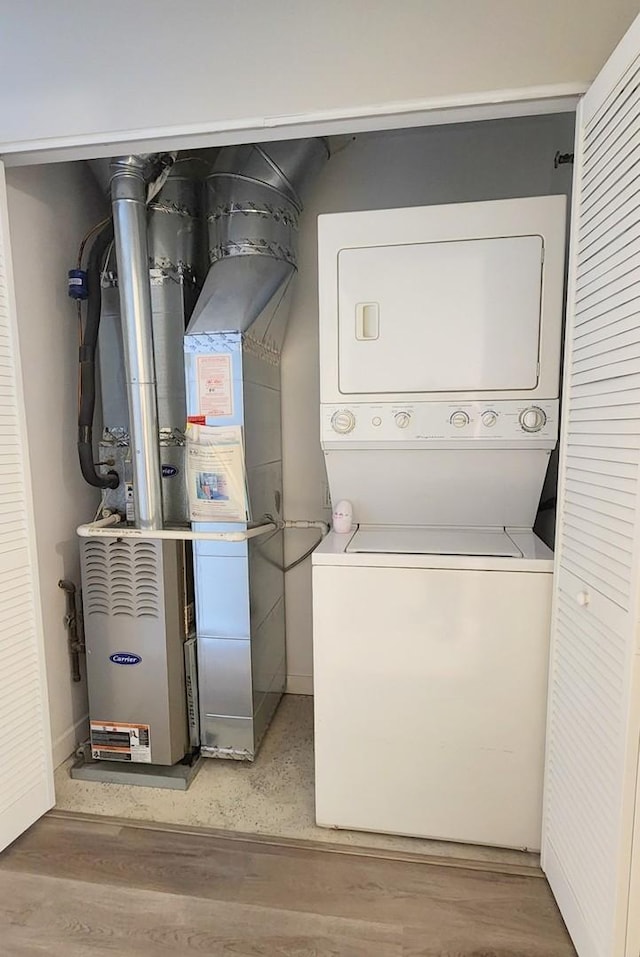 4015 N Milwaukee Ave Unit 516, Chicago, IL 60641 - washroom featuring light wood-style flooring, stacked washer and dryer, laundry area, and heating unit