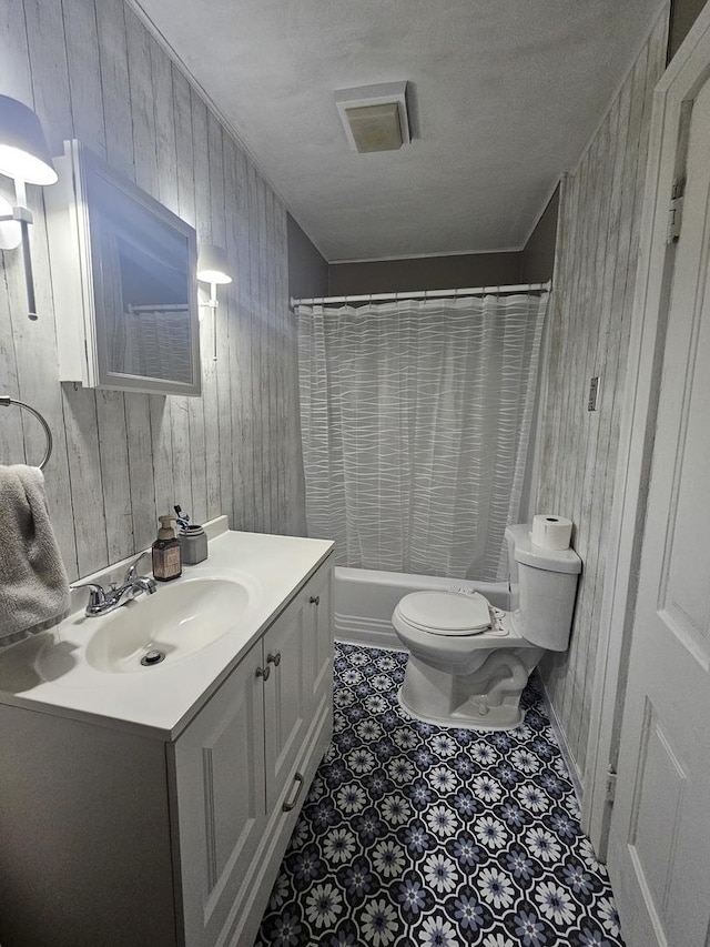 full bath featuring toilet, shower / tub combo with curtain, tile patterned flooring, vanity, and wood walls