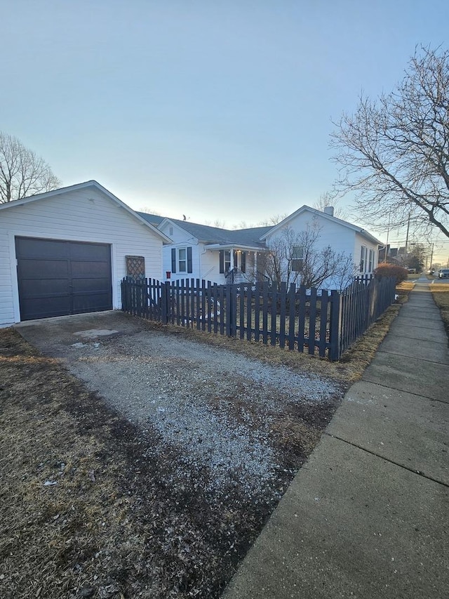 view of front of house featuring a garage, driveway, and a fenced front yard