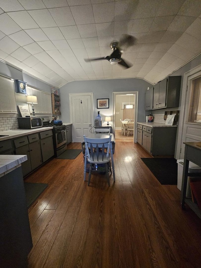 kitchen with stainless steel appliances, light countertops, and vaulted ceiling