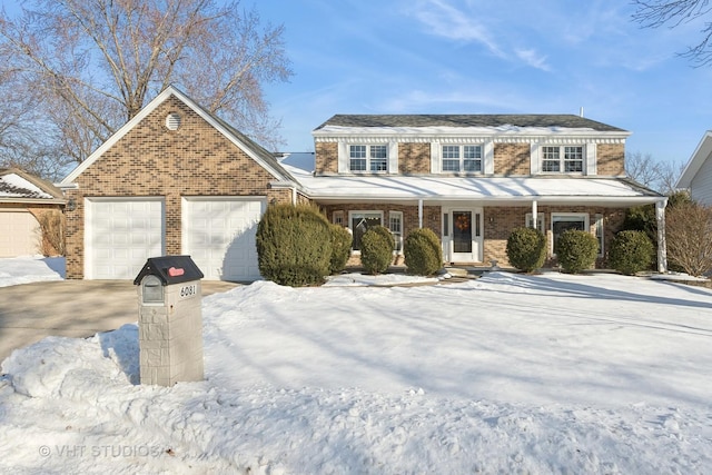 view of front of property featuring an attached garage, driveway, a porch, and brick siding