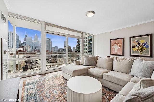 living room featuring visible vents, wood finished floors, a view of city, crown molding, and floor to ceiling windows