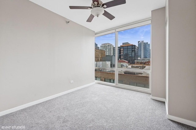 unfurnished room with baseboards, a city view, floor to ceiling windows, and carpet flooring