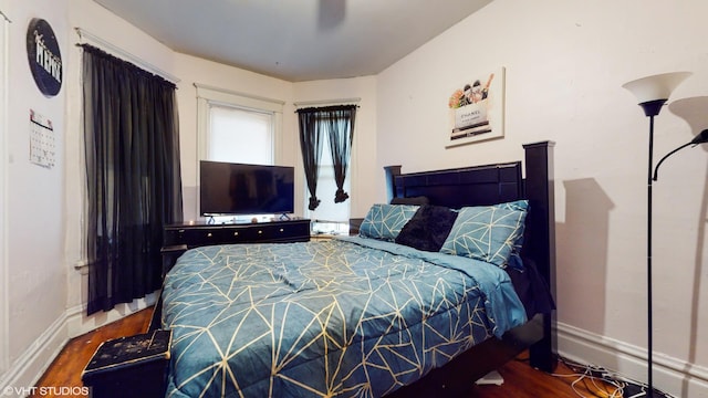 bedroom featuring wood finished floors and baseboards