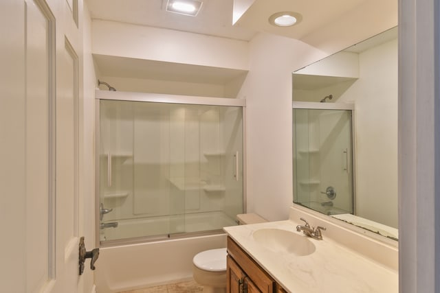 full bath with enclosed tub / shower combo, vanity, and toilet