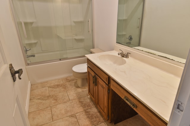 bathroom featuring combined bath / shower with glass door, vanity, toilet, and tile patterned floors