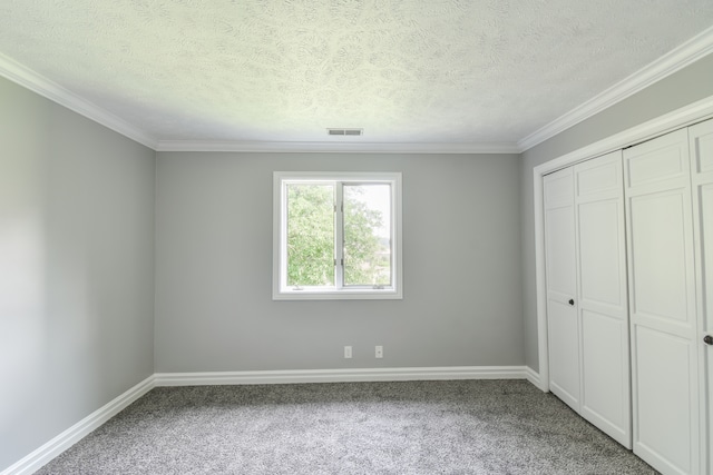 208 Carol Ct Unit A2, Pontiac, IL 61764 - unfurnished bedroom with carpet, a closet, ornamental molding, baseboards, and a textured ceiling