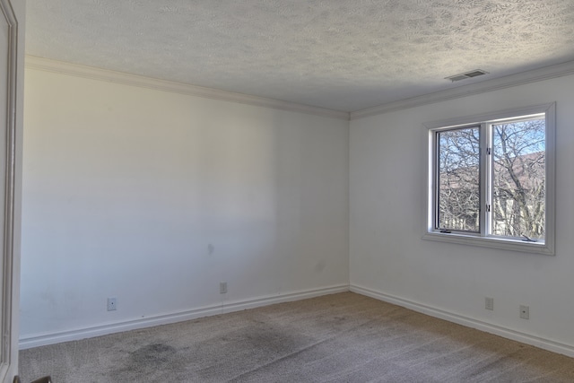 carpeted spare room with baseboards, a textured ceiling, visible vents, and crown molding