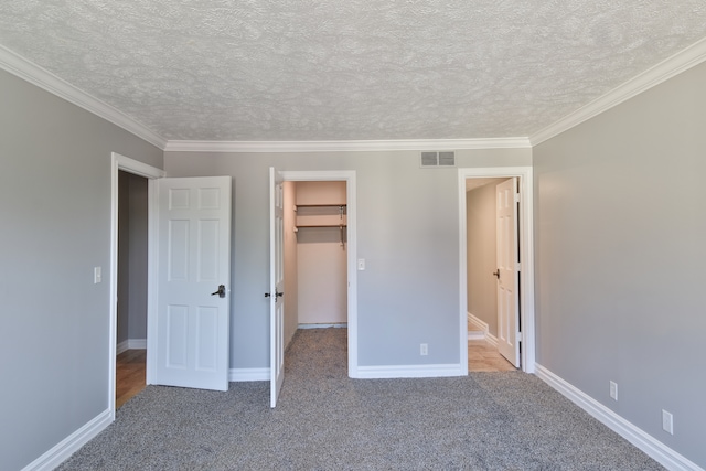 208 Carol Ct Unit A2, Pontiac, IL 61764 - unfurnished bedroom with a spacious closet, carpet floors, crown molding, a textured ceiling, and baseboards