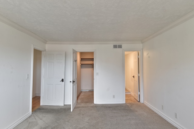 unfurnished bedroom with light carpet, a textured ceiling, visible vents, and baseboards