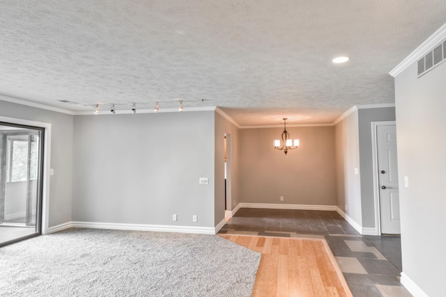 208 Carol Ct Unit A2, Pontiac, IL 61764 - spare room with a chandelier, wood finished floors, baseboards, ornamental molding, and a textured ceiling