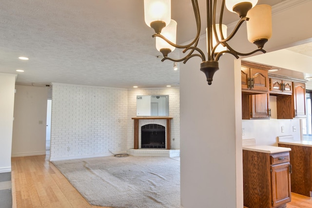 living room with a textured ceiling, light wood finished floors, a fireplace, and a chandelier