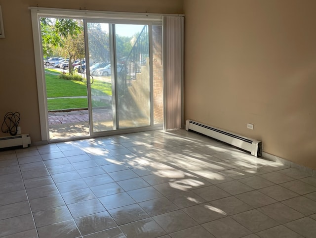 empty room featuring light tile patterned floors and baseboard heating