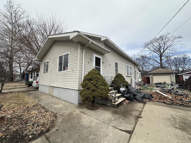 view of side of property featuring a garage and an outbuilding