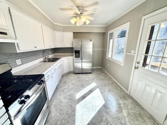 kitchen with white cabinets, backsplash, stainless steel appliances, and a sink