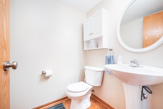 bathroom featuring toilet and baseboards