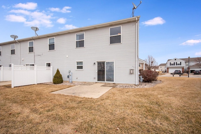 back of property with fence, a patio, and a lawn