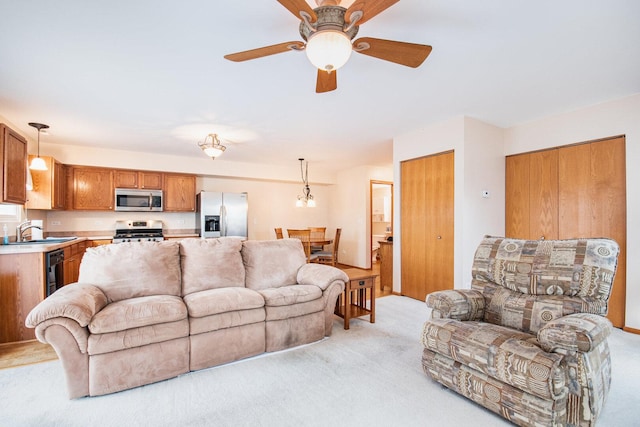 living area with ceiling fan and light colored carpet