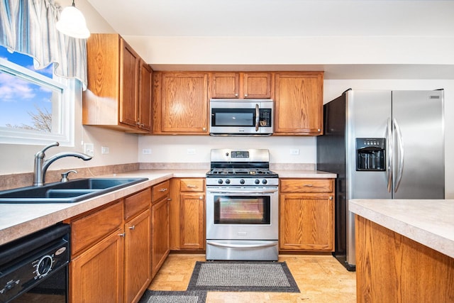 kitchen featuring stainless steel appliances, light countertops, and a sink