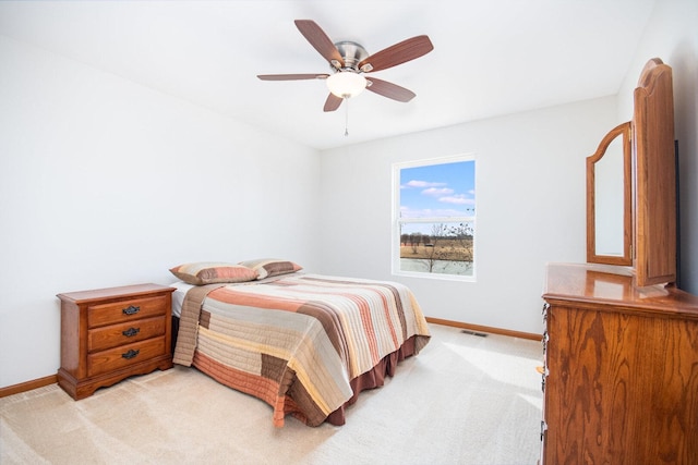 bedroom with baseboards, visible vents, a ceiling fan, and light colored carpet