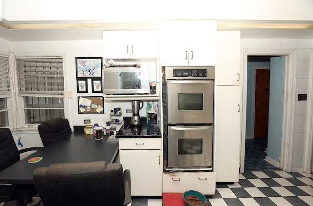 kitchen with tile countertops, tile patterned floors, white cabinets, and stainless steel double oven