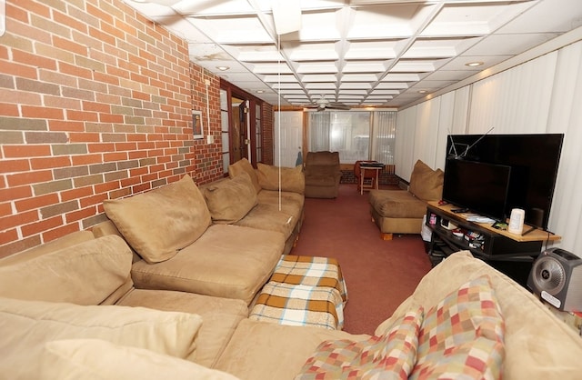 carpeted living room with coffered ceiling and brick wall