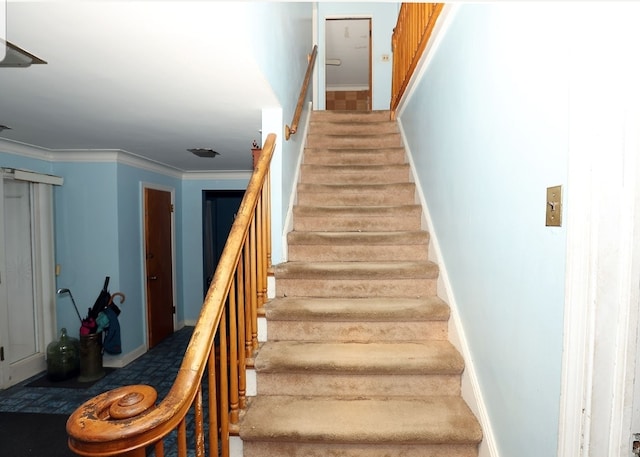 staircase featuring baseboards and ornamental molding