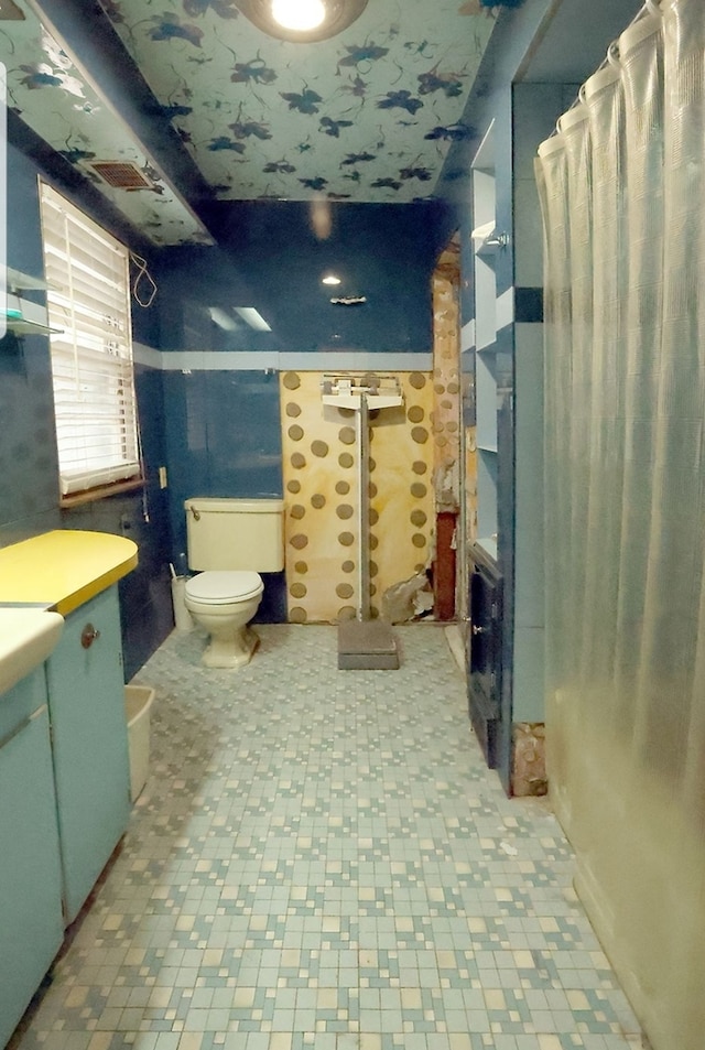 full bathroom featuring curtained shower, toilet, and vanity