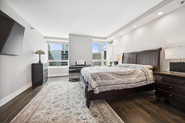 bedroom featuring baseboards, dark wood finished floors, a textured ceiling, and recessed lighting