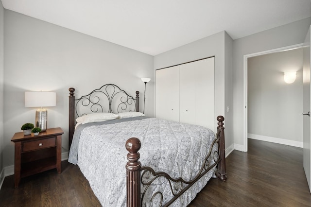 bedroom featuring dark wood-style floors, a closet, and baseboards