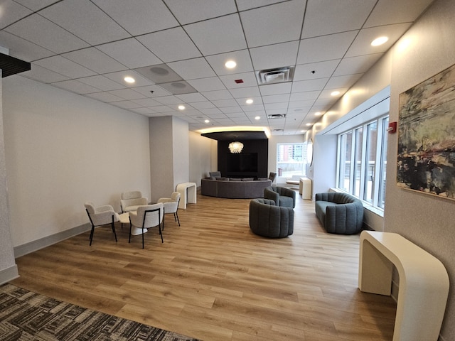 living room featuring recessed lighting, visible vents, wood finished floors, a drop ceiling, and baseboards