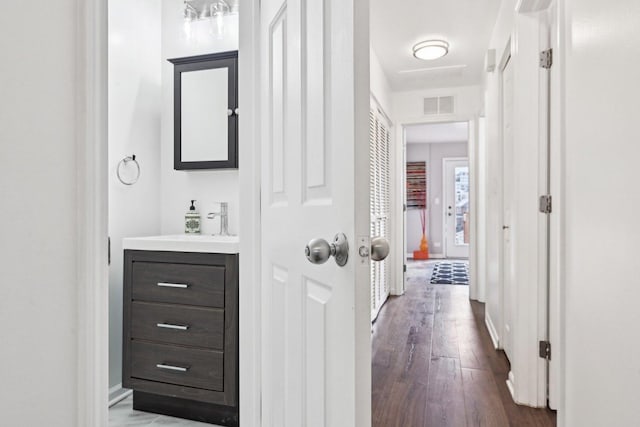 bathroom featuring visible vents, vanity, baseboards, and wood finished floors
