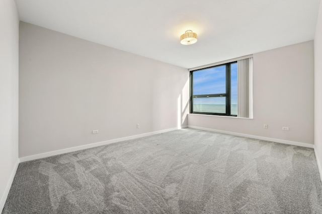 empty room featuring carpet flooring and baseboards