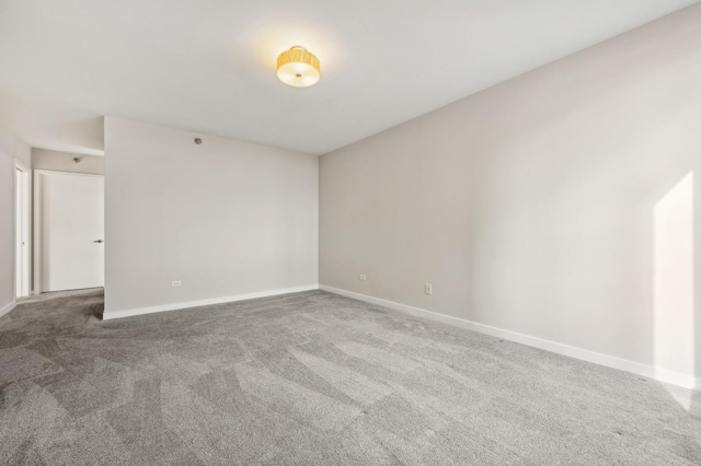 carpeted empty room with baseboards